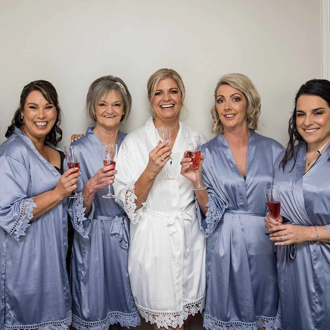 Bride with four bridesmaids in matching blue robes on their wedding day. 