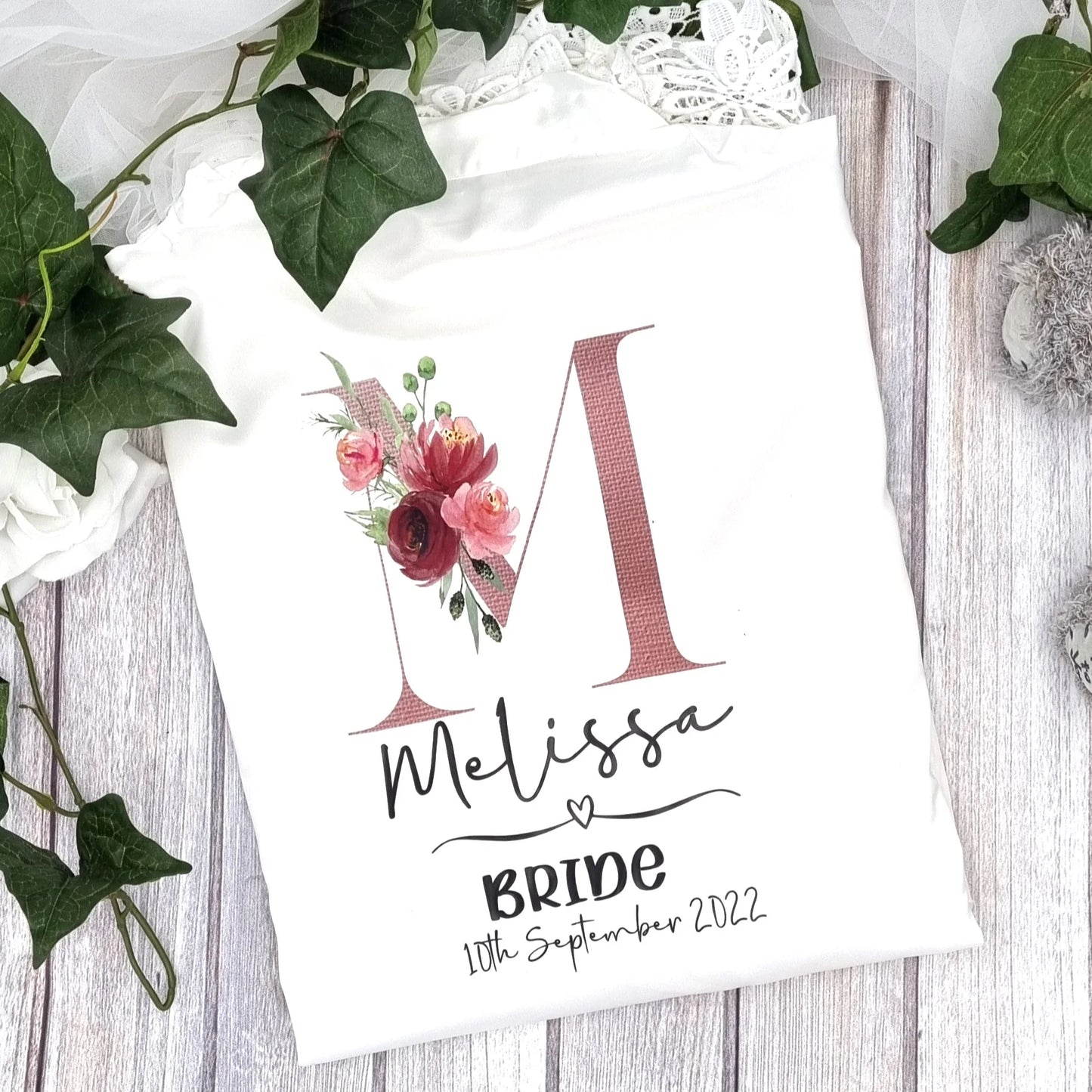 Personalised bride robe in white satin with floral initial “M” design and lace detailing – Irish designed and printed by HanaLee Studios.