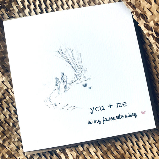 Beautiful white greeting card with small illustration and message reading you and me if my favourite story